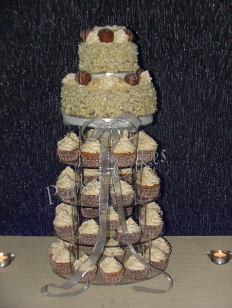 two tier chocolate wedding cake with cupcakes