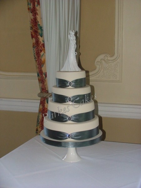 four tier wedding cake with pewter ribbons