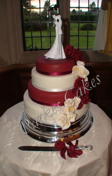 four tier burgundy and ivory wedding cake with cascading roses