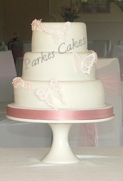 three tier dusky pink wedding cake with royal iced butterflies