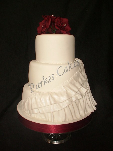three tier wedding cake with burgundy roses & dress detail