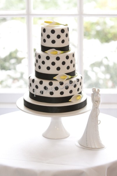 three tier black and white polka dot wedding cake with cala lillies