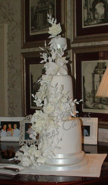 five tier white wedding cake with cascading roses
