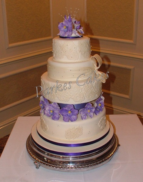 four tier ivory wedding cake with lace pearls and vanda orchids