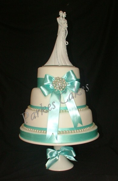 three tier wedding cake with pearls and brooch